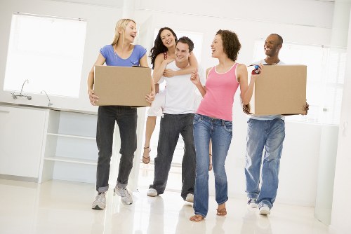 Professional movers carrying furniture through a narrow staircase