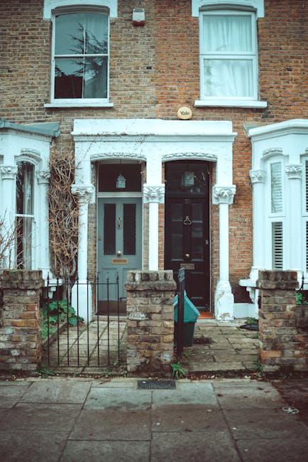 A row of Victorian-style terraced houses with brick facades, prominently featuring ornate white wooden balustrades and decorative trim around the bay windows, situated along a residential street in Ke